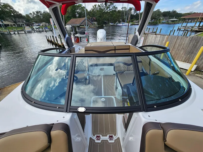 Slide: The Image of 2025 Monterey 235SS boat with sleek design, docked by a scenic waterfront. - 33