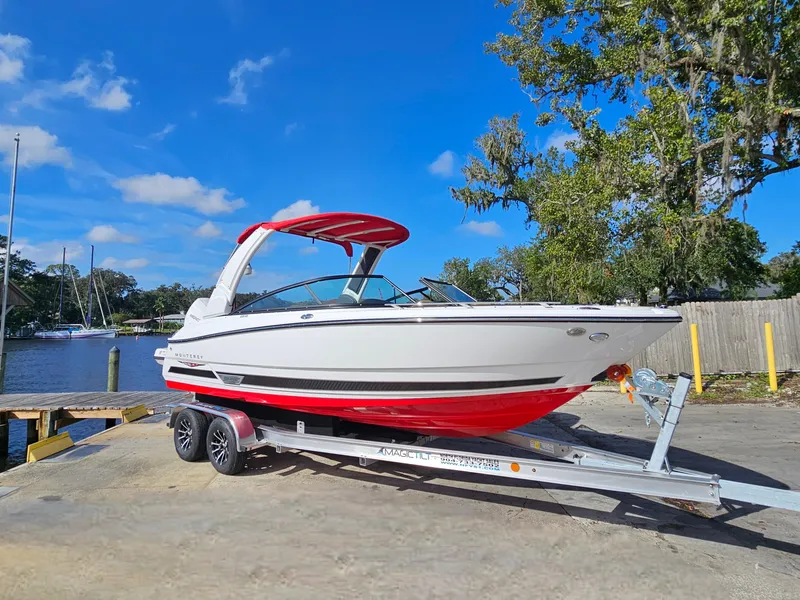 Slide: The Image of 2025 Monterey 235SS boat on trailer by waterfront, clear sky, trees in background. - 4