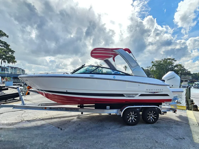 Slide: The Image of 2025 Monterey 235SS boat on trailer, white and red design, parked near waterfront. - 5