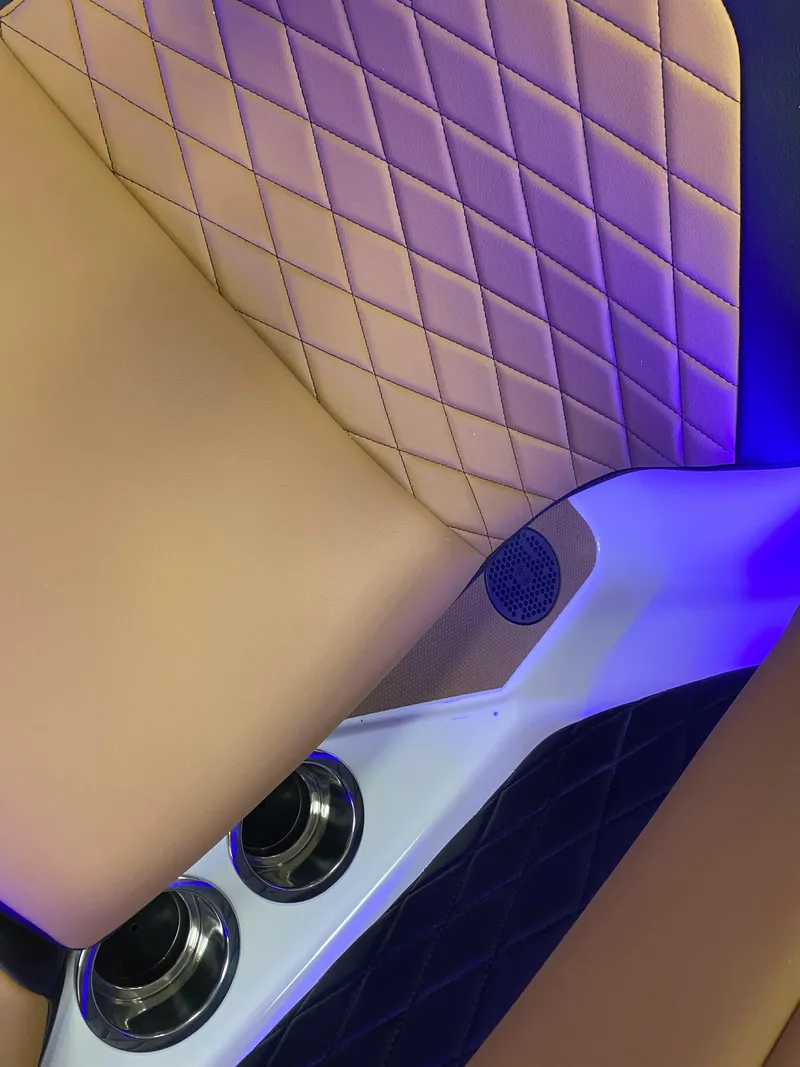 Slide: The Image of 2025 Chaparral 26 Surf interior with quilted leather seats and blue LED lighting. - 10