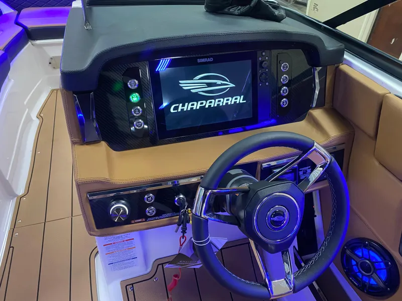 Slide: The Image of 2025 Chaparral 26 Surf boat dashboard with steering wheel and digital display. - 12