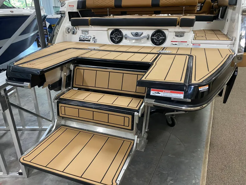 Slide: The Image of 2025 Chaparral 26 Surf boat with tan deck and steps, featuring modern design. - 14