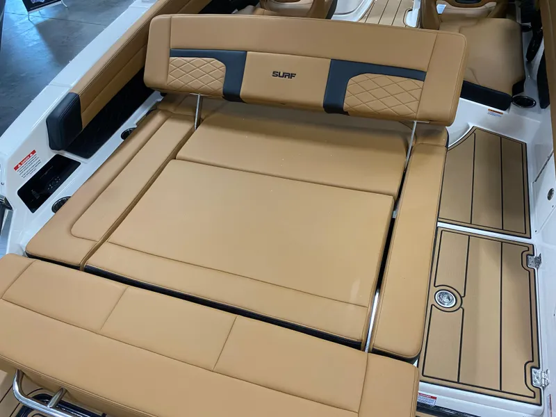 Slide: The Image of 2025 Chaparral 26 Surf boat with tan cushioned seating and wood-style flooring. - 5