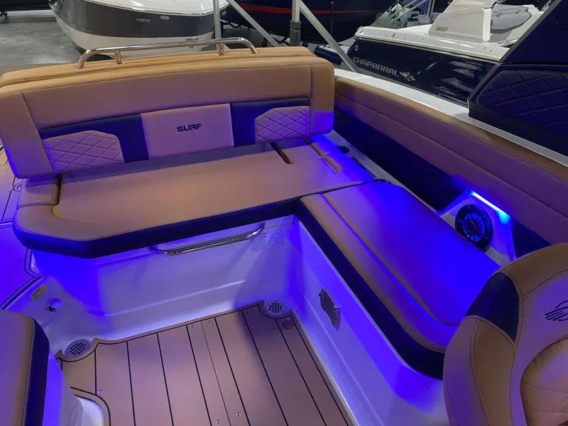 Slide: The Image of 2025 Chaparral 26 Surf boat interior with blue LED lighting and cushioned seating. - 7