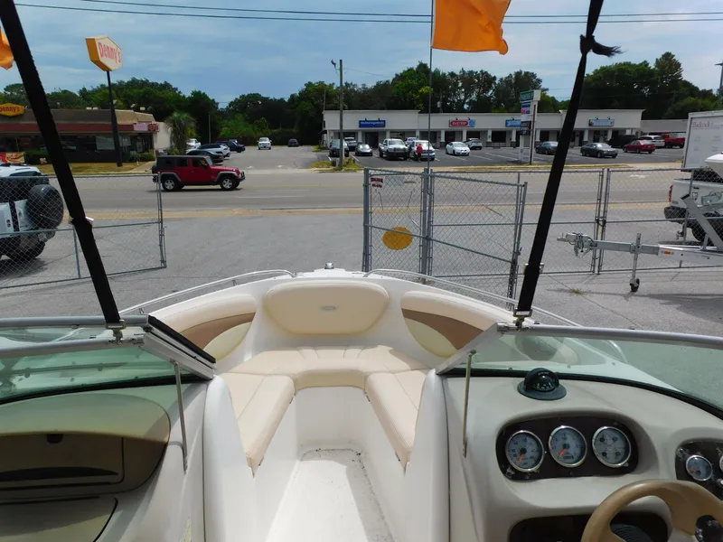 Slide: The Image of 2008 Chaparral 204 SSi boat interior with dashboard and seating, parked near a dealership. - 13
