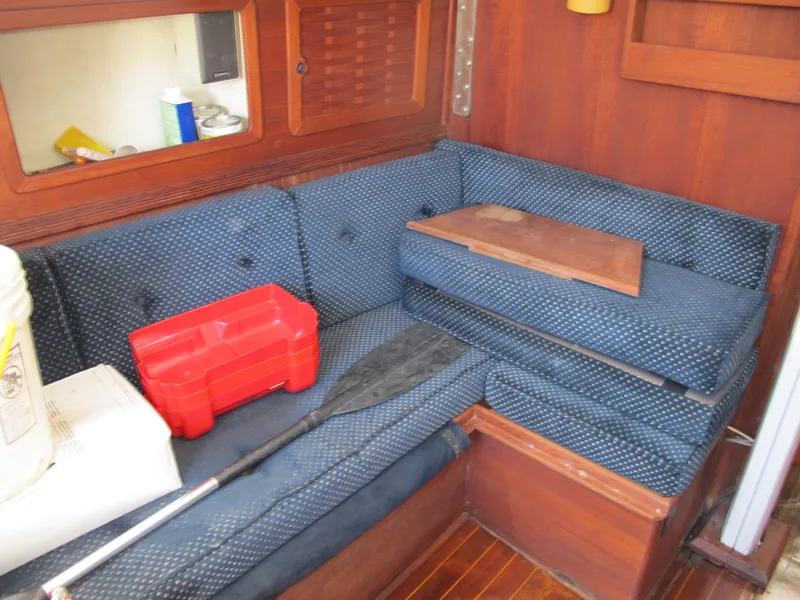 Slide: The Image of Interior of 1987 Sabre 34 sailboat with blue cushioned seating and wooden accents. - 10