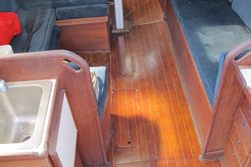 Slide: The Image of 1987 Sabre 34 yacht interior with wooden flooring and seating area. - 13