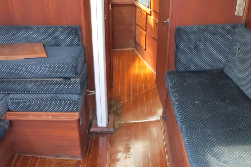 Slide: The Image of Interior of 1987 Sabre 34 sailboat with wooden flooring and blue upholstered seating. - 15