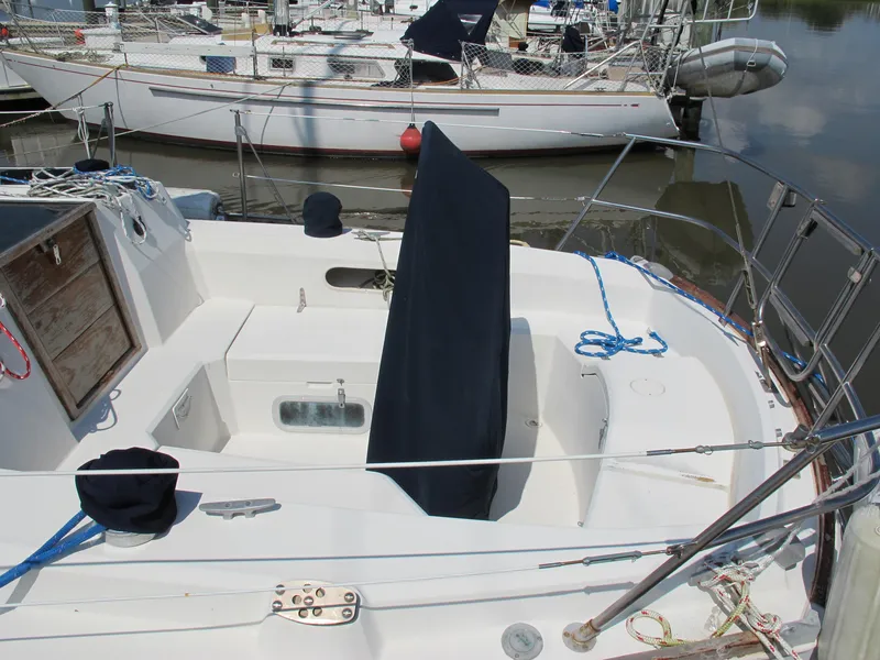 Slide: The Image of 1987 Sabre 34 sailboat cockpit with covered instruments and ropes, docked in a marina. - 4