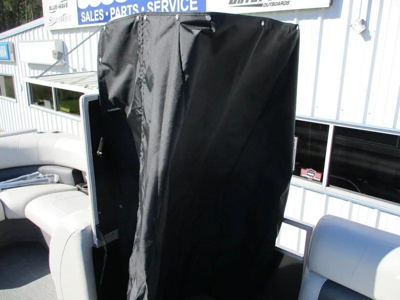 Slide: The Image of Starcraft LX 20 CB 2025 boat interior with black cover, dealership background. - 17