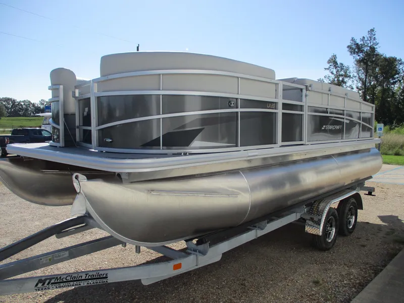 Slide: The Image of 2025 Starcraft LX 20 CB pontoon boat on trailer, silver and gray design. - 3