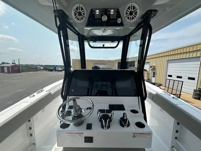 Slide: The Image of 2025 Sportsman 282 Open boat dashboard with steering wheel and controls. - 13