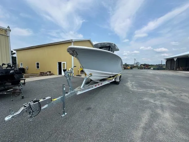 Slide: The Image of 2025 Sportsman 282 Open boat on trailer, parked near industrial buildings under a cloudy sky. - 5