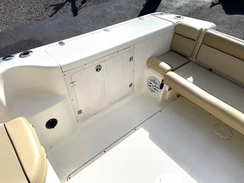 Slide: The Image of 2006 Scout 242 Abaco boat interior with beige seating and storage compartment. - 10