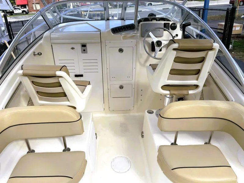 Slide: The Image of 2006 Scout 242 Abaco boat interior with beige seating and steering console. - 13