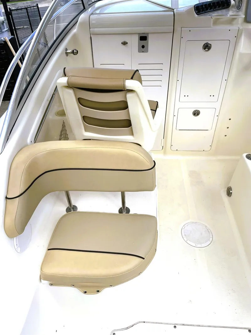 Slide: The Image of 2006 Scout 242 Abaco boat interior with beige seating and storage compartments. - 14