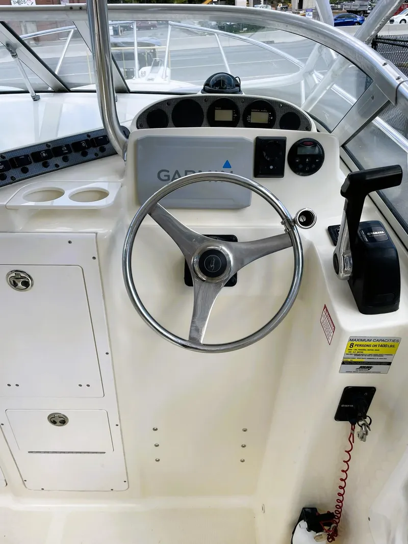 Slide: The Image of 2006 Scout 242 Abaco boat helm with steering wheel and control panel. - 18
