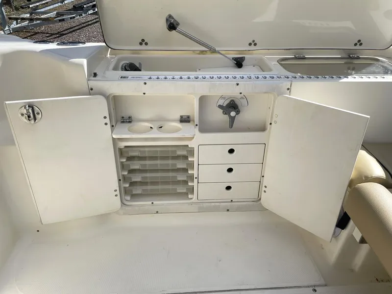 Slide: The Image of 2006 Scout 242 Abaco boat storage compartment with open doors and drawers. - 2