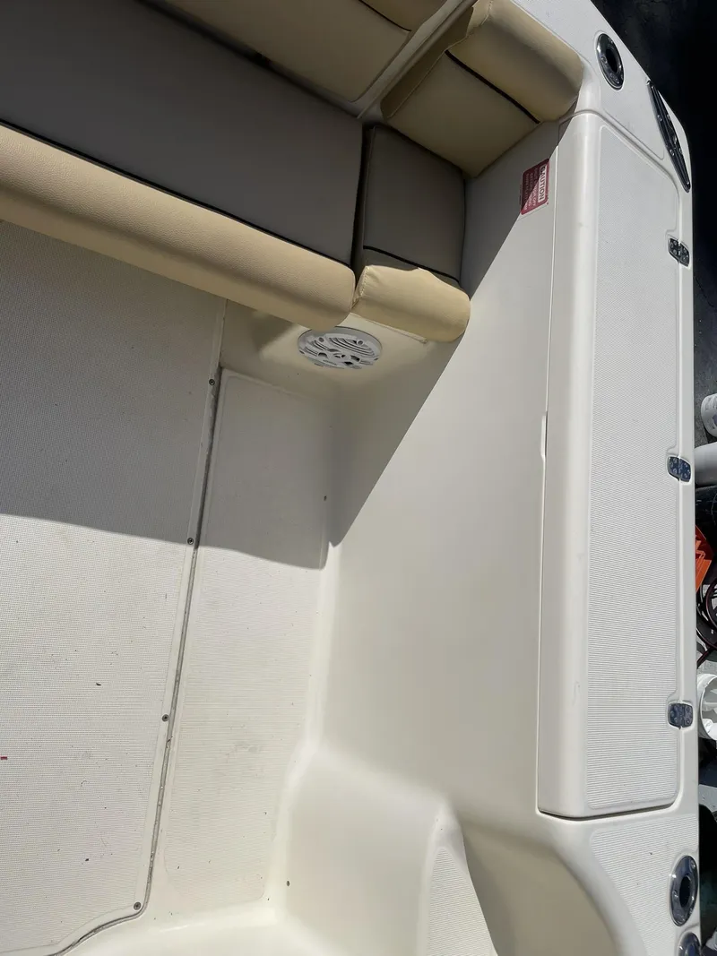 Slide: The Image of 2006 Scout 242 Abaco boat interior with beige seating and storage compartments. - 7