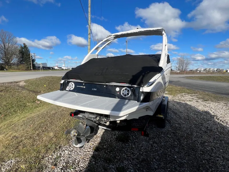 Slide: The Image of 2025 Regal LS4 boat on trailer, rear view, under clear blue sky. - 2