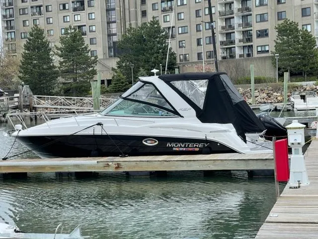 Slide: The Image of 2021 Monterey 295 Sport Yacht docked in marina, cityscape background. - 0