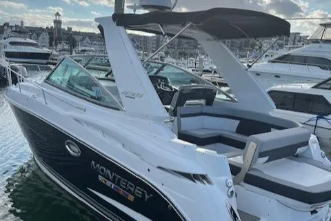 Slide: The Image of 2021 Monterey 295 Sport Yacht docked in marina, showcasing sleek design and spacious seating. - 13