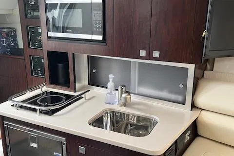 Slide: The Image of Modern kitchenette in 2021 Monterey 295 Sport Yacht with sink, stove, and microwave. - 19