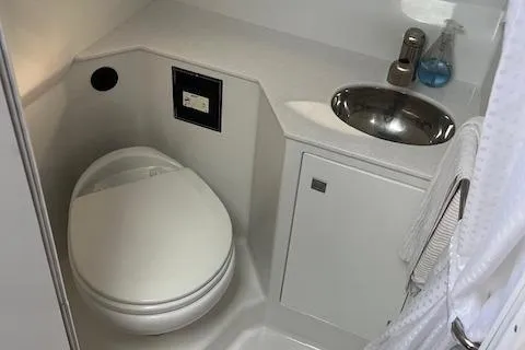 Slide: The Image of 2021 Monterey 295 Sport Yacht bathroom with toilet and sink. - 2