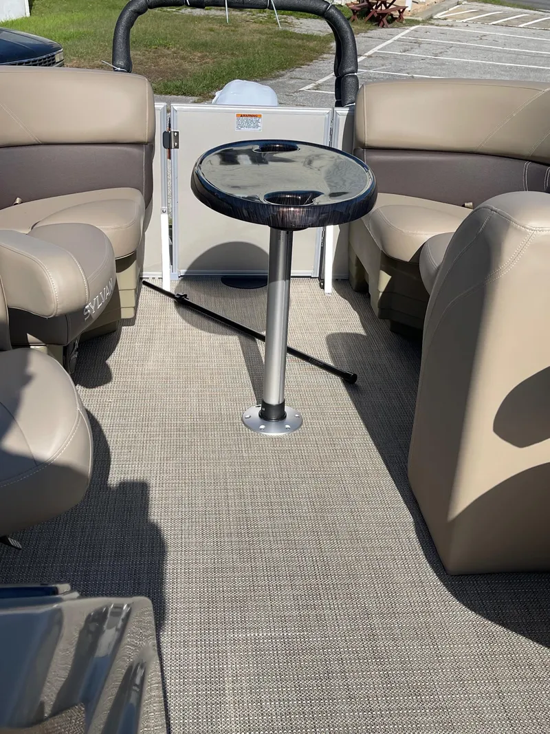 Slide: The Image of 2025 Sylvan 820 Mirage Cruise interior with beige seating and central table. - 12