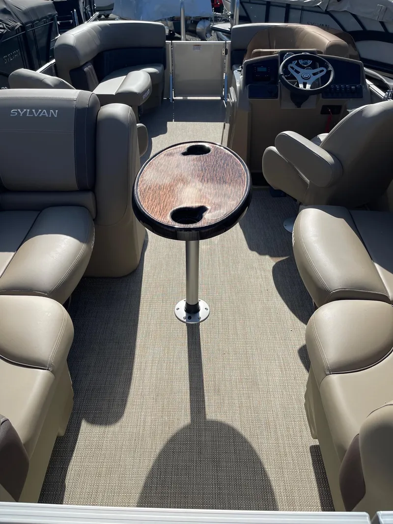 Slide: The Image of 2025 Sylvan 820 Mirage Cruise interior with plush seating and central table. - 13