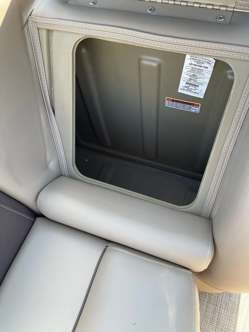 Slide: The Image of 2025 Sylvan 820 Mirage Cruise storage compartment with beige seating. - 16