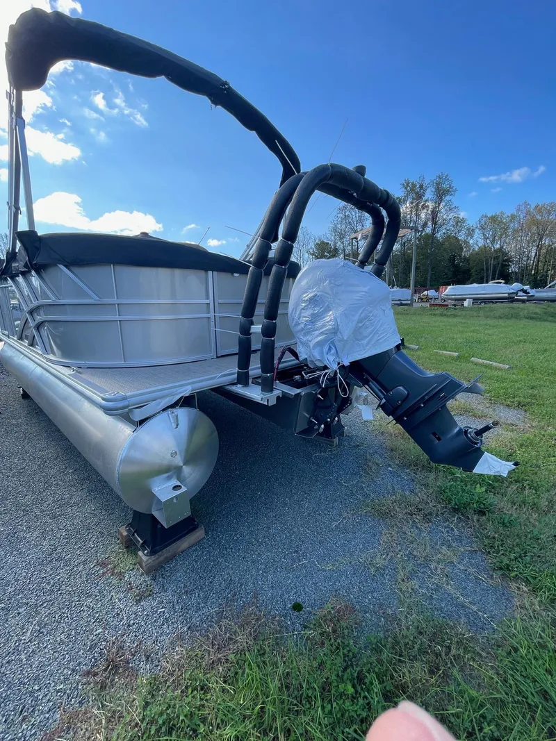 Slide: The Image of 2025 Sylvan 820 Mirage Cruise pontoon boat with outboard motor on grassy area. - 2