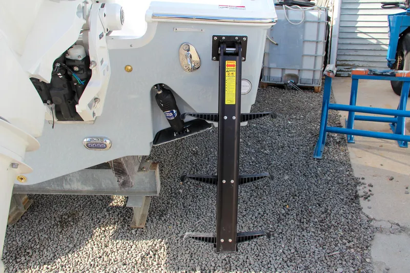 Slide: The Image of 2025 Sea Hunt Ultra 265 SE boat with mounted ladder on gravel surface. - 10