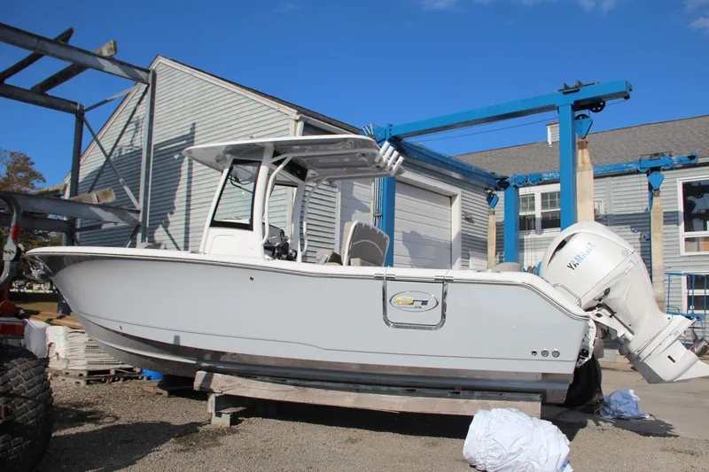 Slide: The Image of 2025 Sea Hunt Ultra 265 SE boat in a marina setting, side view. - 12