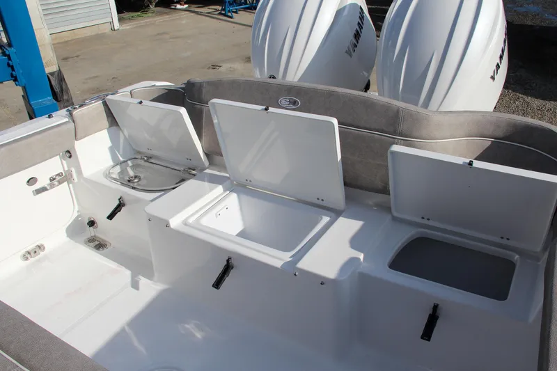 Slide: The Image of 2025 Sea Hunt Ultra 265 SE boat with open storage compartments and dual engines. - 17