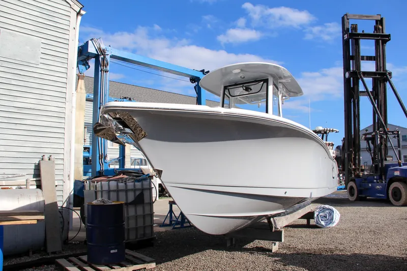 Slide: The Image of 2025 Sea Hunt Ultra 265 SE boat in a marina, clear sky background. - 2