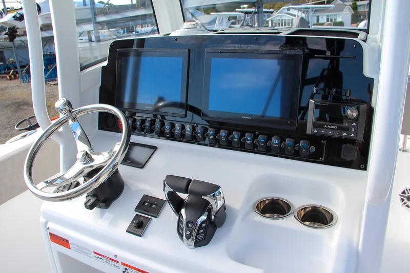 Slide: The Image of 2025 Sea Hunt Ultra 265 SE boat dashboard with dual screens and steering wheel. - 44
