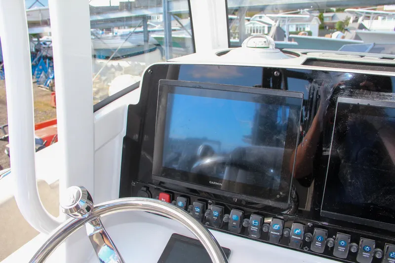 Slide: The Image of 2025 Sea Hunt Ultra 265 SE boat dashboard with navigation screens and controls. - 48