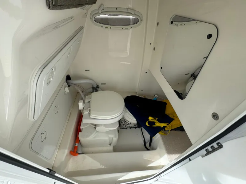 Slide: The Image of 2022 Sea Pro 259 Center Console boat interior with toilet and storage space. - 24