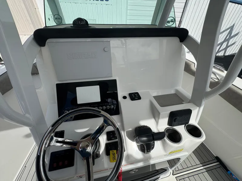 Slide: The Image of 2022 Sea Pro 259 Center Console helm with steering wheel and controls. - 32