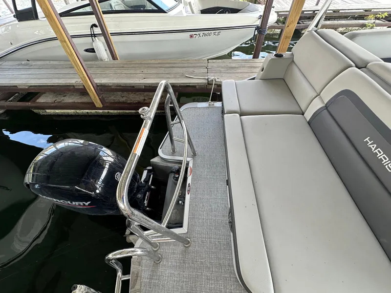 Slide: The Image of 2024 Harris FloteBote HCX 23 pontoon boat with Mercury outboard motor, docked in marina. - 17