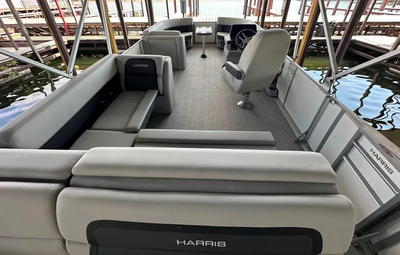 Slide: The Image of 2024 Harris FloteBote HCX 23 pontoon boat interior with spacious seating and helm. - 18