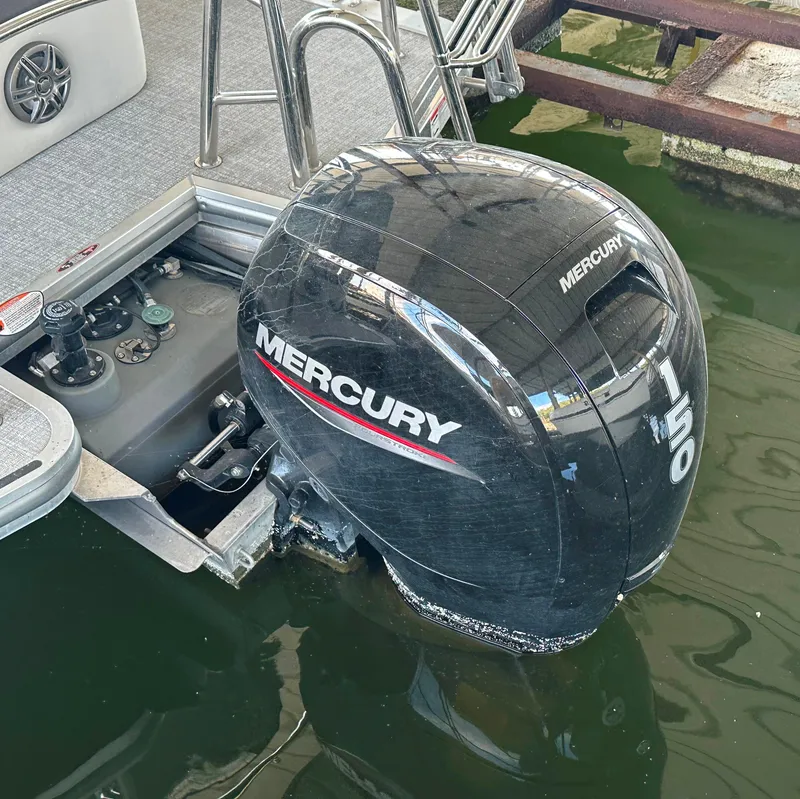 Slide: The Image of 2024 Harris FloteBote HCX 23 with Mercury 150 outboard motor in water. - 21