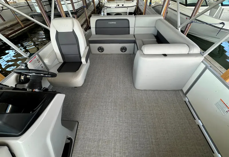 Slide: The Image of 2024 Harris FloteBote HCX 23 pontoon boat interior with modern seating and steering console. - 7