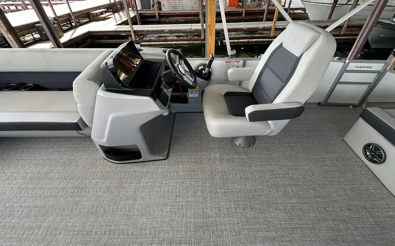 Slide: The Image of 2024 Harris FloteBote HCX 23 boat interior with captain's chair and console. - 9