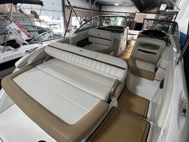 Slide: The Image of 2021 Cobalt 23SC boat interior with beige and white seating in showroom. - 4