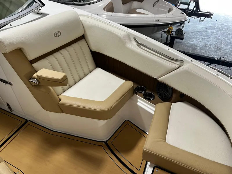 Slide: The Image of 2021 Cobalt 23SC boat interior with beige and white seating, cup holders, and armrest. - 7
