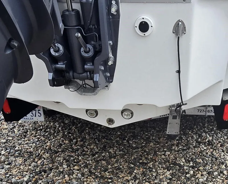 Slide: The Image of 2023 Tidewater 232 SS boat stern with motor and trailer on gravel. - 12