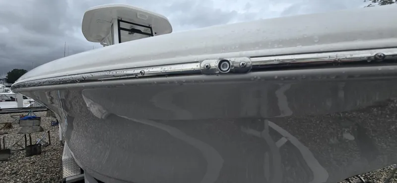 Slide: The Image of 2023 Tidewater 232 SS boat with sleek design, docked under cloudy skies. - 13