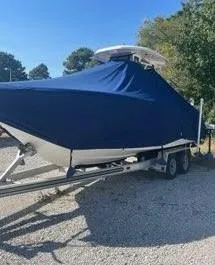 Slide: The Image of 2023 Tidewater 232 SS boat covered on trailer, parked outdoors. - 16